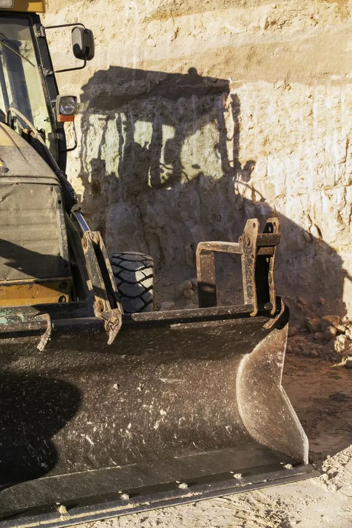 Backhoe loader excavating ground at a road and infrastructure site